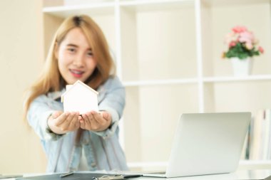 Genç kadın ev satın almak planlama. Ev modeli, seçici odak.