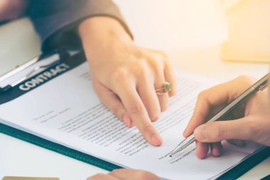 İşkadını işaretleri sözleşmesi sözleşme ile ofiste başka bir iş kadını. Kadının el ateş yakın. İş ortaklığı ve avukat yasal faaliyetleri kavramı.