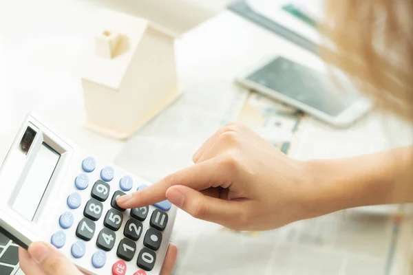 Woman accountant or bank worker uses calculator in the office to calculate house loan credit bureaucracy.