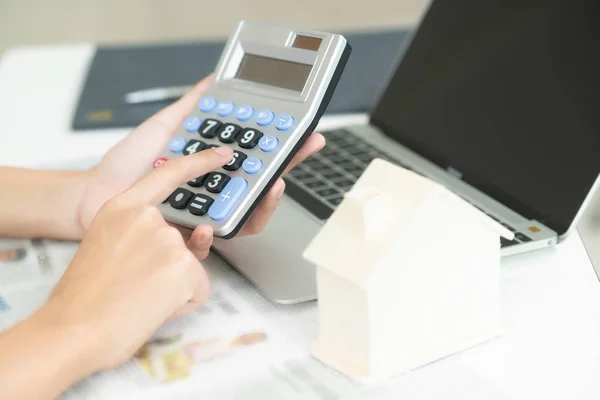 Woman accountant or bank worker uses calculator in the office to calculate house loan credit bureaucracy.