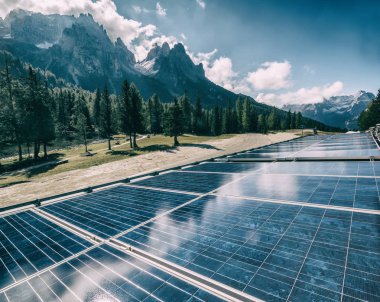 Güneşli gökyüzü ve dağ arkaplanlarına karşı kırsal alandaki güneş paneli. Güneş enerjisi, dünya enerjisinin sürdürülebilirliği için bir yeniliktir. Sürdürülebilir kaynaklar.