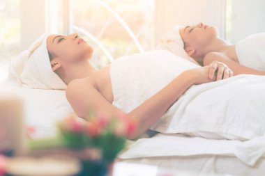 Spa yatağında uzanan rahat genç bir kadın lüks bir spa merkezinde yüz bakımı ve masaj için hazırlandı. Sağlık, stres atma ve gençleştirme kavramı.