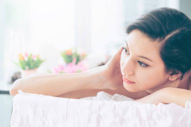 Lüks spa merkezinde masaj tedavisi için hazırlanan spa yatakta yalan rahat genç kadın. Sağlık, stres rahatlama ve gençleşme kavramı.