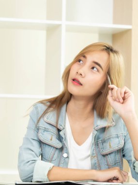 Yaratıcı genç kadın gelecekteki eğitim veya rahat ev ofisinde otururken bir iş kurma hakkında düşünüyorum. Gençlik başlangıç iş ve eğitim kavramı.