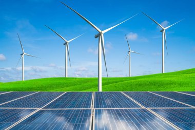 Güneş paneli ve rüzgar türbinleri çiftliği bir yeşil tepeler mavi gökyüzü ve beyaz bulutlar karşı yaz aylarında çim. Yenilenebilir temiz enerji ve sürdürülebilirlik iş geliştirme kavramı.