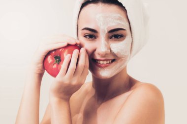 Bir yüz maskesi tedavi ile domates krem ayıklayabilirsiniz doğa tedavisinin yararı gösterilen sahip güzel bir kadın. Anti-aging kozmetik, yüz cilt bakımı ve lüks yaşam tarzı kavramı.