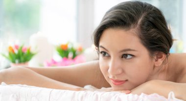 Lüks spa merkezinde masaj tedavisi için hazırlanan spa yatakta yalan rahat genç kadın. Sağlık, stres rahatlama ve gençleşme kavramı.