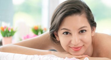 Lüks spa merkezinde masaj tedavisi için hazırlanan spa yatakta yalan rahat genç kadın. Sağlık, stres rahatlama ve gençleşme kavramı.