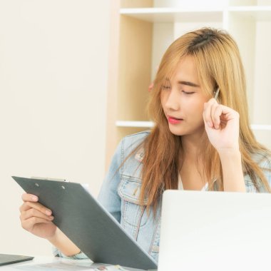 İş kadını iş raporu ile rahat bir ev ofis konsantrasyon düşünürken bakar. Küçük işletmeler ve kavram kurmak.