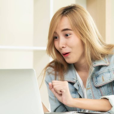 Sevimli kadın rahat ev ofis dizüstü bilgisayarda bakarken hayran, heyecan veya sürpriz hisseder. İnanılmaz satış reklam ve şanslı ödül kazanan kavramı.