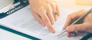 İşkadını işaretleri sözleşmesi sözleşme ile ofiste başka bir iş kadını. Kadının el ateş yakın. İş ortaklığı ve avukat yasal faaliyetleri kavramı.