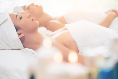 Spa yatağında uzanan rahat genç bir kadın lüks bir spa merkezinde yüz bakımı ve masaj için hazırlandı. Sağlık, stres atma ve gençleştirme kavramı.