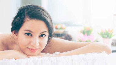 Lüks spa merkezinde masaj tedavisi için hazırlanan spa yatakta yalan rahat genç kadın. Sağlık, stres rahatlama ve gençleşme kavramı.