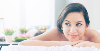 Lüks spa merkezinde masaj tedavisi için hazırlanan spa yatakta yalan rahat genç kadın. Sağlık, stres rahatlama ve gençleşme kavramı.