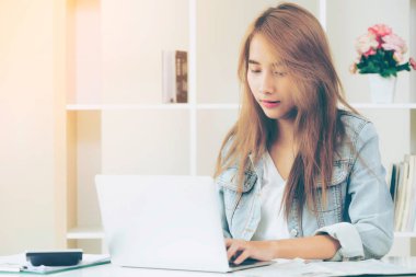 Konsantre kadın rahat ev ofis dizüstü bilgisayarda çalışıyor. Küçük işletmeler ve iş kavramı devreye.