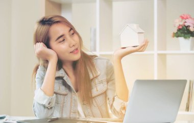 Genç kadın ev satın almak planlama. Emlak ve gayrimenkul yatırım karar verme.