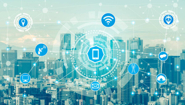 Smart city wireless communication network with graphic showing concept of internet of things ( IOT ) and information communication technology ( ICT ) against modern city buildings in the background.