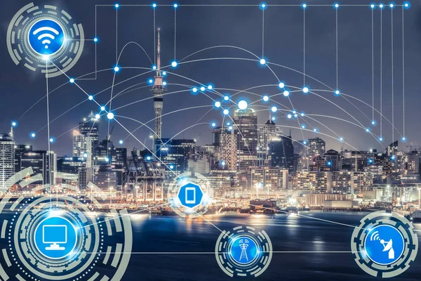 Smart city wireless communication network with graphic showing concept of internet of things ( IOT ) and information communication technology ( ICT ) against modern city buildings in the background.
