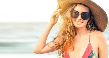Tatil seyahat etmek tatil için yaz aylarında tropikal plaj keyfi yerinde mayo giyen mutlu genç kadın.