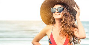 Tatil seyahat etmek tatil için yaz aylarında tropikal plaj keyfi yerinde mayo giyen mutlu genç kadın.