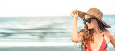 Tatil seyahat etmek tatil için yaz aylarında tropikal plaj keyfi yerinde mayo giyen mutlu genç kadın.