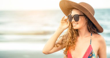 Tatil seyahat etmek tatil için yaz aylarında tropikal plaj keyfi yerinde mayo giyen mutlu genç kadın.