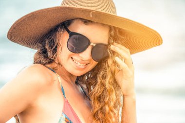 Tatil seyahat etmek tatil için yaz aylarında tropikal plaj keyfi yerinde mayo giyen mutlu genç kadın.