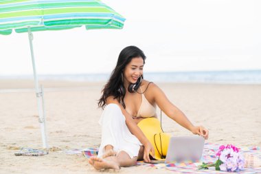 Artı boyutu yaz aylarında tropikal Kum Plajı üzerinde oturan bir genç bayan. Tatil seyahat etmek tatil.