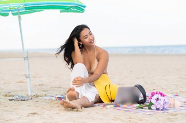 Artı boyutu yaz aylarında tropikal Kum Plajı üzerinde oturan bir genç bayan. Tatil seyahat etmek tatil.