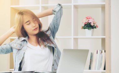 Çalışma ofisinde bittiğinde rahat genç kadın kol ve omuz kas uzanır. Memnun ve endişesiz iş iş kavramı.