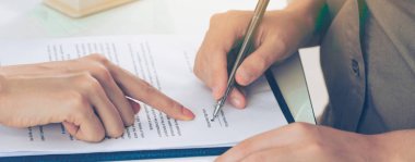 İşkadını işaretleri sözleşmesi sözleşme ile ofiste başka bir iş kadını. Kadının el ateş yakın. İş ortaklığı ve avukat yasal faaliyetleri kavramı.