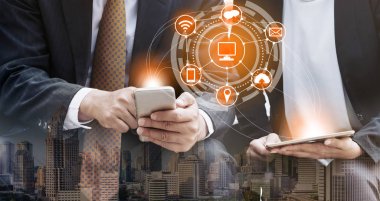 Cep telefonu ile modern şehir binaları arka plan kullanarak genç iş adamları. Gelecekteki telekomünikasyon teknolojisi ve internet şeyler (çok) kavramının.