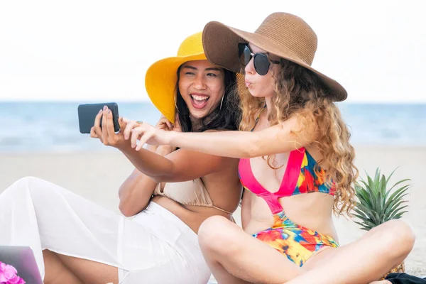 Mutlu kadın selfie fotoğraf birlikte cep telefonundan tropikal kum plaj yaz tatile içinde bikinis. Seyahat yaşam tarzı.