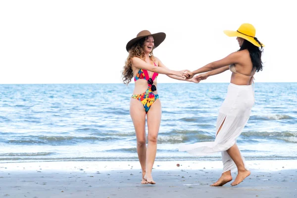 Bikinili mutlu kadın birlikte yaz tatil tropikal Kum Plajı üzerinde dans. Seyahat yaşam tarzı.