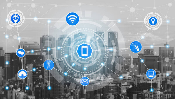 Smart city wireless communication network with graphic showing concept of internet of things ( IOT ) and information communication technology ( ICT ) against modern city buildings in the background.