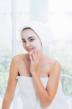 Beautiful woman having a facial cosmetic scrub treatment from professional dermatologist at wellness spa. Anti-aging, facial skin care and luxury lifestyle concept. clipart