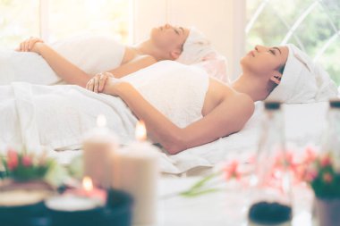 Spa yatağında uzanan rahat genç bir kadın lüks bir spa merkezinde yüz bakımı ve masaj için hazırlandı. Sağlık, stres atma ve gençleştirme kavramı.