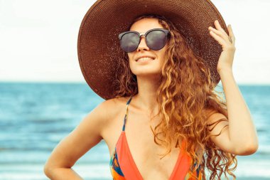Tatil seyahat etmek tatil için yaz aylarında tropikal plaj keyfi yerinde mayo giyen mutlu genç kadın.