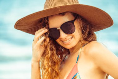 Tatil seyahat etmek tatil için yaz aylarında tropikal plaj keyfi yerinde mayo giyen mutlu genç kadın.