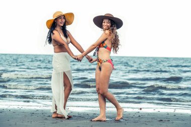 Bikinili mutlu kadın birlikte yaz tatil tropikal Kum Plajı üzerinde dans. Seyahat yaşam tarzı.