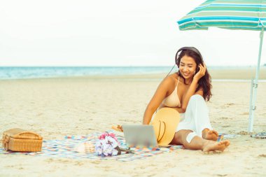 Artı boyutu yaz aylarında tropikal Kum Plajı üzerinde oturan bir genç bayan. Tatil seyahat etmek tatil.