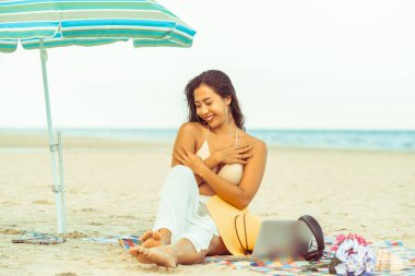 Artı boyutu yaz aylarında tropikal Kum Plajı üzerinde oturan bir genç bayan. Tatil seyahat etmek tatil.