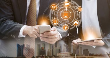 Cep telefonu ile modern şehir binaları arka plan kullanarak genç iş adamları. Gelecekteki telekomünikasyon teknolojisi ve internet şeyler (çok) kavramının.