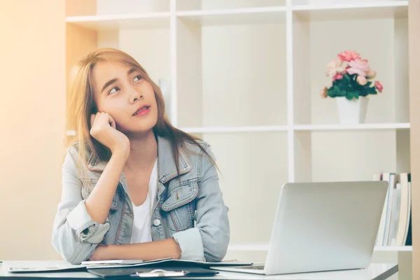 Creative young woman think about future education or starting a business while sitting in cozy home office. Youth startup business and education concept.