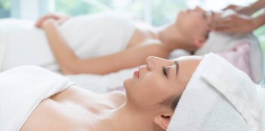 Spa yatağında uzanan rahat genç bir kadın lüks bir spa merkezinde yüz bakımı ve masaj için hazırlandı. Sağlık, stres atma ve gençleştirme kavramı.