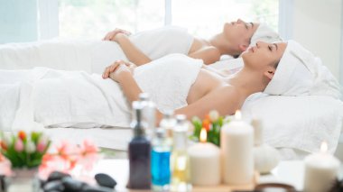 Spa yatağında uzanan rahat genç bir kadın lüks bir spa merkezinde yüz bakımı ve masaj için hazırlandı. Sağlık, stres atma ve gençleştirme kavramı.