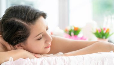 Lüks spa merkezinde masaj tedavisi için hazırlanan spa yatakta yalan rahat genç kadın. Sağlık, stres rahatlama ve gençleşme kavramı.