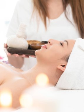 Rahat kadın kaplıca tedavisi planda tutan terapist ile spa masaj için hazırlanan spa yatakta yalan. Lüks sağlık, stres rahatlama ve gençleşme kavramı.