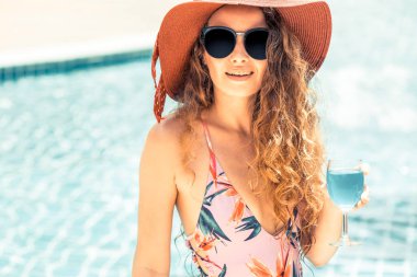 Mutlu genç kadın lüks resort yüzme havuzunda, iyi vakit geçiriyor mayo giyiyor. Yaz seyahat tatil kavramı.