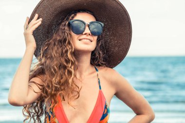 Tatil seyahat etmek tatil için yaz aylarında tropikal plaj keyfi yerinde mayo giyen mutlu genç kadın.